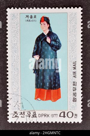 Abgesagte Briefmarke gedruckt von Nordkorea, die Nationalkostüm zeigt, um 1977. Stockfoto