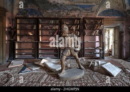 September 2020. Italien. Alte Bronzestatuette auf einem alten Tisch im Wohnzimmer, in einem verlassenen Haus. Urbex in Italien. Stockfoto