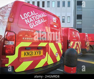 Linie der geparkten Royal Mail roten und gelben Lieferwagen, Kettering, England. Stockfoto