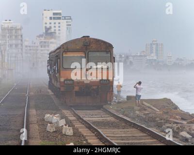 Zug durch den Nebel zum Kollupitiya Bahnhof in Colombo, Sri Lanka. Der Bahnhof ist einer der verkehrsreichsten Bahnhöfe an der Küste Stockfoto