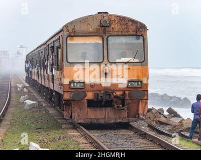 Zug durch den Nebel zum Kollupitiya Bahnhof in Colombo, Sri Lanka. Der Bahnhof ist einer der verkehrsreichsten Bahnhöfe an der Küste Stockfoto