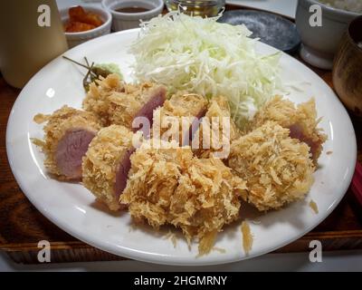 Tonkatsu, ein japanisches paniertes, frittiertes Schweinekotelett. Serviert mit Kohlsalat und Wasabi. Stockfoto