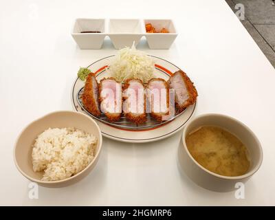 Tonkatsu, ein japanisches Schweineschnitzel mit Kohlsalat und Wasabi. Serviert mit Reis und Misosuppe. Stockfoto