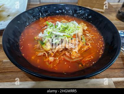 Jjamppong, eine koreanische chinesische Nudelsuppe mit roter, würziger Schweinebühe, gewürzt mit Chilipulver. Stockfoto