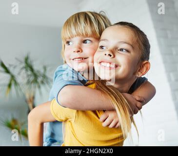 Kind Mädchen junge Kindheit Kind Bruder Schwester Liebe Familie zusammen Spaß glücklich Freude Glück niedlich Huckepack umarmt Stockfoto
