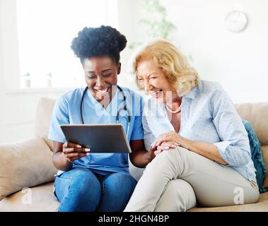 Krankenschwester Arzt Senior care Betreuer Hilfe Tablet-Technologie Altersheim Krankenpflege ältere Frau Gesundheit unterstützen afroamerikanischen schwarz Stockfoto