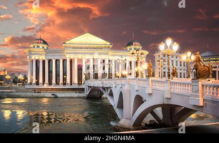 Skopje, Republik Nordmakedonien. Das archäologische Museum von Mazedonien und die Brücke der Zivilisationen bei Sonnenuntergang. Stockfoto