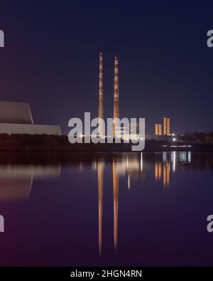 Poolbeg Kamine reflektierten sich während der Dämmerung am Sandymount Strand Stockfoto