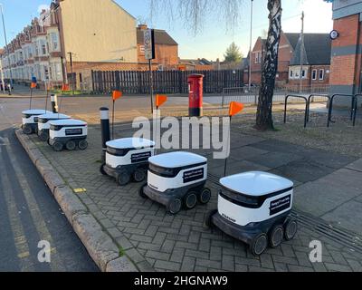 Elektrische Lieferfahrzeuge CO OP Northampton UK geparkt fertig mitgenommen Postfach Linie ausgerichtet Flaggen kleiner elektrischer weißer Kunststoff Stockfoto