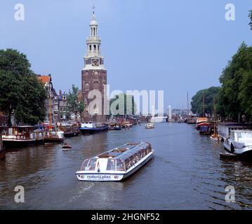 Niederlande. Amsterdam. Montelbaan Tower. Boote auf dem Oudeschans-Kanal. Stockfoto