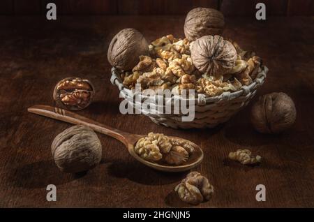 Walnüsse und Kerne in einem Korb auf einem dunklen Holzhintergrund Stockfoto