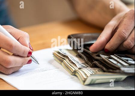 Nahaufnahme einer Frau, die einen Vertrag unterzeichnet Stockfoto