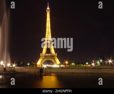 Oft fokussiert. Eiffelturm in paris mit verschwommenem Paar im Hintergrund, Frankreich bei Nacht, Eiffelturm mit Lichtvorstellung, der Eiffelturm ist Stockfoto