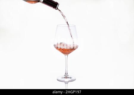 Glas, das Wein aus einer Flasche serviert Stockfoto
