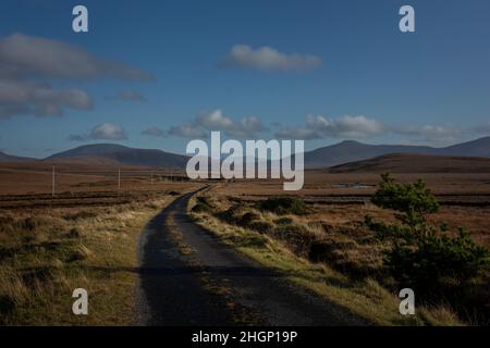 Bogroad am Rande des Ballycroy National Park mit riesigen Torfgebieten und den Wild Nephin Mountains am Horizont. Stockfoto