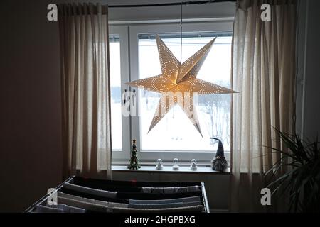 Weihnachtsschmuck in einem Haus am zweiten Adventssonntag. Ein Adventsstern in einem Fenster. Stockfoto