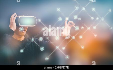 Geschäftsmann trägt Virtual-Reality-Brille VR und Touch-Grafik-Bildschirm eines Medienbildschirms auf dem dunklen Hintergrund, Technology Process System Business, Stockfoto