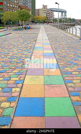 Farbenfroher Wanderweg am Riachuelo-Fluss mit der ehemaligen Transporterbrücke von Buenos Aires im Hintergrund, La Boca, Buenos Aires, Argentinien Stockfoto