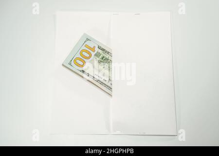 Dollar im Wind auf weißem Hintergrund, viel Geld in einem Umschlag. Stockfoto