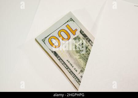 Dollar im Wind auf weißem Hintergrund, viel Geld in einem Umschlag. Stockfoto