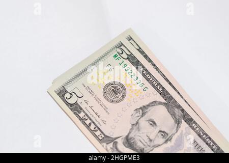 Die Zisterne der Banknoten liegt auf einem weißen Tisch. Viele Dollar, ein Haufen Dollar. Stockfoto