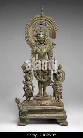 Vishnu flankiert von seinen personifizierten Attributen Anfang des 9th. Jahrhunderts Indien (Bihar) Vishnu ruht seine untere rechte Hand auf Chakrapurusha, der Personifizierung seines Kriegsdiskus, dem Chakra. Seine linke untere Hand liegt auf dem Kopf von Gadadevi, der weiblichen Personificaiton seiner Keule. Vishnu flankiert von seinen personifizierten Attributen. Indien (Bihar). Anfang des 9th. Jahrhunderts. Bronze. Pala-Periode. Skulptur Stockfoto