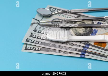 Zahnärztliche Reinigungsgeräte mit Zahnbürste und Bargeld. Mundgesundheit, Untersuchung und Zahnreinigung Konzept. Stockfoto