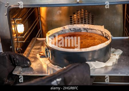 Kochvorgang hausgemachter baskischer gebrannter Käsekuchen. Fertig gerösteter san sebastian Kuchen ist im Ofen. Tarta de Queso. Rezept Schritt für Schritt. Stockfoto
