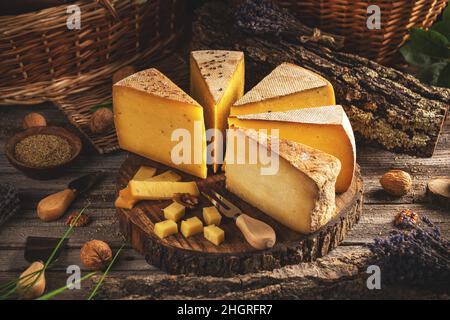 Verschiedene Arten von halbhartem gereiftem Käse auf Holzhintergrund Stockfoto