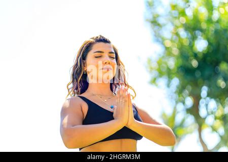 Junge indische attraktive Frau praktiziert Yoga, tief ruhige Atmung im Freien im Sommer grünen Park Stockfoto