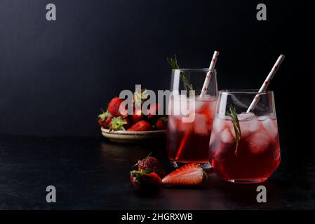 Sommerlich kalte Erdbeercocktails in Gläsern auf schwarzem Hintergrund Stockfoto