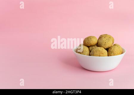 Haferflocken-Kekse auf einem weißen Teller auf einem rosa Hintergrund mit Platz für Text auf der linken Seite. Gesundes Lebensmittelkonzept. Hochwertige Fotos Stockfoto