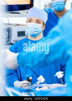 Porträt einer Chirurgen-Frau während einer laparoskopischen Operation. Eine Ärztin führt eine chirurgische Operation mit chirurgischen Manipulatoren durch. Stockfoto