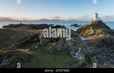 Landschaft der Insel Llanddwyn mit schroffer Küste und Leuchtturm Stockfoto