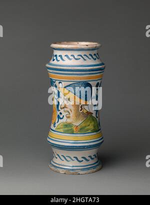 Apothekendose (albarello) ca. 1545 Werkstatt von Masséot Abaquesne Dieses Glas mit Tulpen und einem grotesken Kopf im Profil wurde entwickelt, um Kräuter, Pulver und andere trockene Medikamente zu lagern, die durch ein Stück Pergament, das um die Öffnung herum gesichert worden wäre, vor Verderb geschützt worden wären. Der Container war wahrscheinlich Teil einer Bestellung von 4.152 Schiffen, die 1545 von einem Apotheker bei Masséot Abaquesne, der mit seinem Sohn Laurent eine große Werkstatt Betrieb, aufgegeben wurde. Apothekenbecher (albarello). Französisch, Rouen. Ca. 1545. Zinnglasierte Steingut. Keramik-Keramik Stockfoto