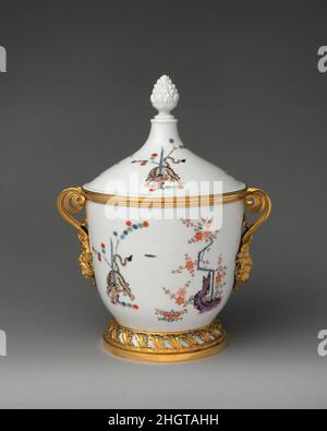 Eisbecher (einer von einem Paar) Porzellan ca. 1730, Halterungen ca. 1780–90 Meissener Manufaktur Deutsch ursprünglich hergestellt, um Eis zu enthalten, wurden diese hochgedeckten Gläser um 1730 in der Meissener Fabrik hergestellt. Eingehauene Inventarmarken deuten darauf hin, dass sie ursprünglich Teil der sächsischen königlichen Sammlungen waren, die im Japanischen Palast in Dresden untergebracht waren, wo die enormen Bestände an asiatischem und Meißener Porzellan von August dem Starken ausgestellt wurden. Archivdokumente deuten darauf hin, dass diese Gläser aus dem Japanischen Palast entfernt und mit ähnlich dekoriertem Meissen Porzellan kombiniert wurden, wie für Stockfoto