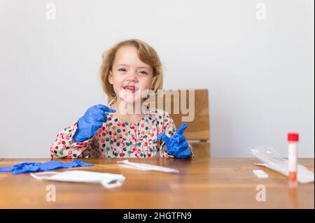 Cute blonde Mädchen Selbsttest für Corona-Virus und warten auf Ergebnisse. Stockfoto