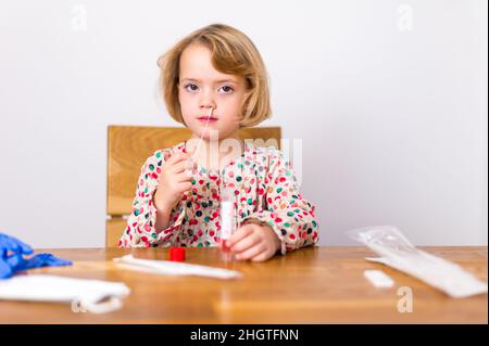 Cute blonde Mädchen Selbsttest für Corona-Virus und warten auf Ergebnisse. Stockfoto