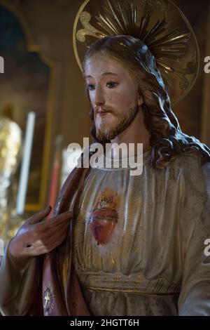 Alte Statue von Jesus Christus der gute Hirte mit Loch in der Hand zeigt auf sein heiliges Herz und Aureole - biblische Tradition, Religion, Chris Stockfoto