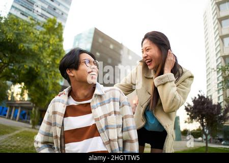 Glücklich lächelndes asiatisches Paar, das Spaß hat und sich anschaut. Junge Liebhaber machen Urlaub. Jugendkultur und Stadtleben. Stockfoto