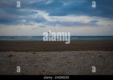 Mann läuft, am Strand von El Trabucador, Sant Carles de la Rapita, Ebro Delta, Naturpark, Tarragona, Spanien Stockfoto