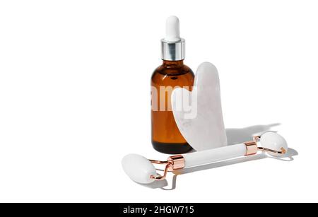 Gua Sha Massagegeräte für eine bessere Durchblutung und ätherisches Öl isoliert auf weißem Hintergrund mit Schneideweg. Hauspflegekonzept für zu Hause. Stockfoto