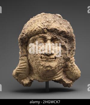 Head of a female ca. 2000–1600 B.C. Babylonian This head, broken at the neck and hollow on the inside, depicts a female figure with shoulder length hair arranged in bands of braids around her head and alongside her face. She has large eyes, a small thin smile, and large ears protrude from her hair. Seven bands around her neck represent a multi-strand necklace. The head appears to have been hand-formed out of wads of clay, then fired and painted. The quality of the clay – tempered with organic matter – may account, in part, for its poor preservation. Based on incrustations of dirt that appear o Stock Photo