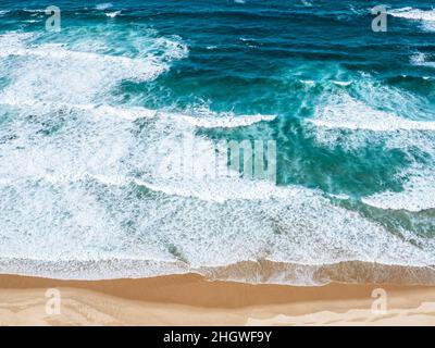 Türkisfarbene Wellen schlagen am Strand Praia do Castelejo in der Algarve in Portugal Stockfoto