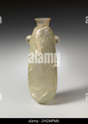 Glas-Alabastroon (Parfümflasche) ca. 625–600 v. Chr. wahrscheinlich phönizische Farbigkeit mit blassgrünlicher Färbung, Rand mit abgeflachten, waagerechten Lippen; kurzer, trichterförmiger Hals; Abgerundete Schulter; länglicher eiförmiger Körper; runder Boden; am Oberkörper zwei fest vorstehende, Halbrunde Griffe, nach außen verjüngend, aus dem Körper des Gefäßes geschnitzt.zerbrochen und repariert mit mehreren Bereichen des Einfüllkörpers; Nadelstichtblasen; Abstumpfen, Lochfraß und kleine Flecken von dicker, weißer Verwitterung.das Alabastron wurde gegossen und dann zu seiner jetzigen Form geschliffen. Die Phönizier waren wahrscheinlich wichtige Vermittler im Introdu Stockfoto