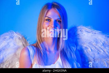 Valentines Engel Mädchen. Valentinstag Amor. Lächelnde Frau mit weißen Flügeln in Neon. Stockfoto