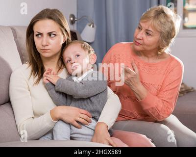 Zwei Erwachsene Frauen haben Meinungsverschiedenheiten mit dem erwachenden Kind Stockfoto