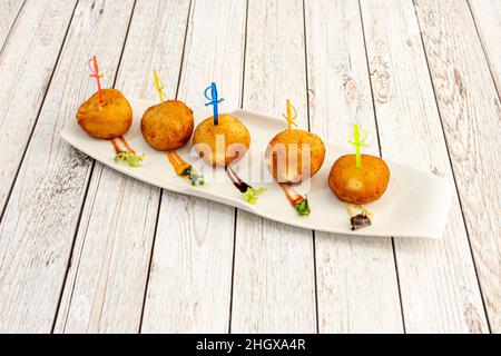 Hausgemachte kroketten mit serrano-Schinken auf einem weißen Tablett Stockfoto