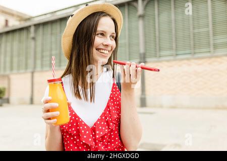 Fröhliche Frau mit Handy in der Stadt Straße Stockfoto