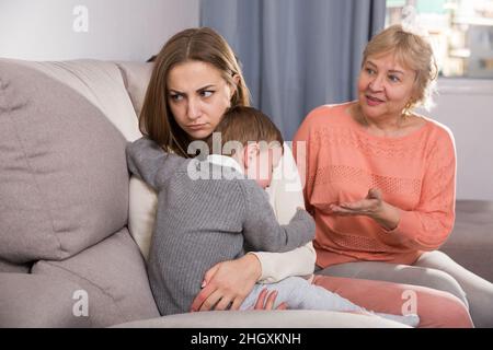 Erwachsene Frauen mit ihrer Mutter haben Meinungsverschiedenheiten über die Elternschaft des Kindes Stockfoto